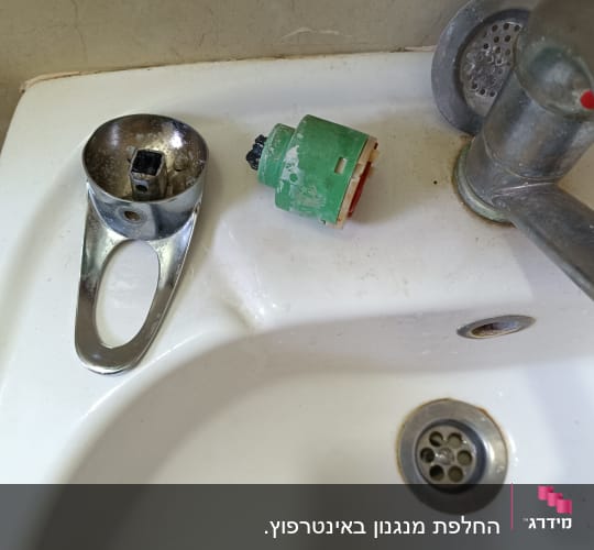 ברז מפורק עם חלקים על כיור